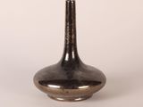 silver vase on a white surface with a white background