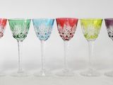 six different colored wine glasses are lined up in a row