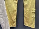 deux pantalons jaunes et blancs suspendus à un portant