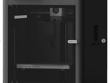une imprimante 3D noire posée sur une surface blanche