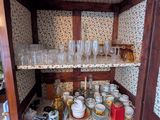une armoire en bois contenant de nombreuses pièces en verre