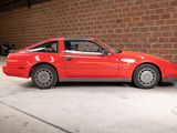 an image of a red car parked in front of a brick wall