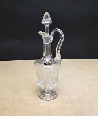 une photo d'un vase en verre transparent posé sur une table en bois