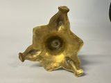 an image of a gold colored candle holder on a white surface