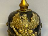 un casque noir et doré orné d'une décoration dorée