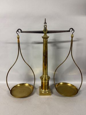 a brass scale with two empty trays sitting on top of it