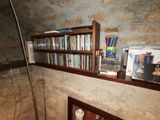 a book shelf that has a lot of books on top of it