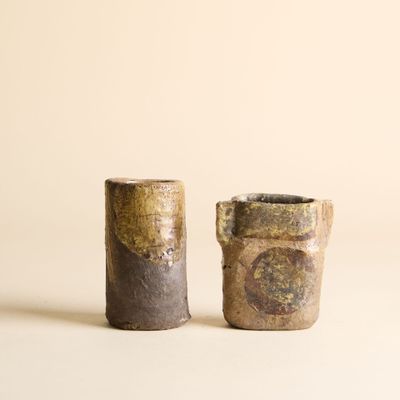 deux petits vases posés l'un à côté de l'autre sur une table