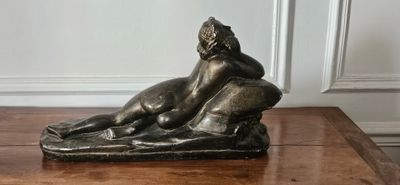 une statue en bronze représentant un homme et un chien posée sur une table