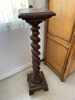 a tall wooden table with a glass top on it