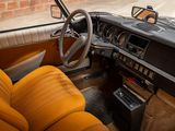 a dashboard and steering wheel of a car with a brick wall in the background
