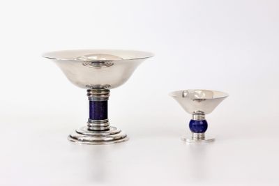 un bol en argent et un verre bleu posés sur une table