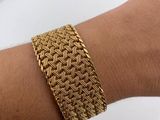 a close up of a person ' s arm wearing a gold bracelet