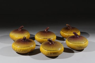 six bols jaunes et marron avec leurs couvercles, posés sur une surface blanche