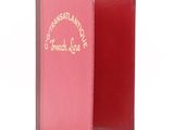un livre rouge ouvert sur une surface blanche