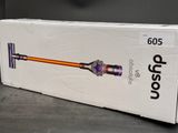 Coffret d'un aspirateur sans fil posé sur une surface grise