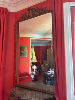 une pièce rouge avec des rideaux rouges et un miroir accroché au mur