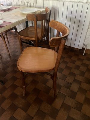 plusieurs chaises et une table dans une pièce au sol en briques