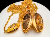 a white plate with a gold locke and a gold chain on it