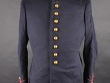 a blue military jacket with gold buttons on a mannequin dummy
