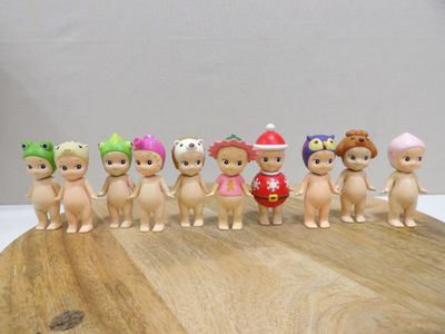 sept petites figurines de tailles différentes posées sur une planche en bois