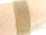 bracelet on a woman ' s arm with a gold chain bracelet