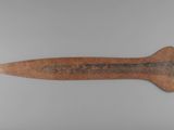 a close up of a wooden knife on a white surface