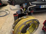 a fire hydrant and a hose on the ground next to a car