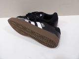 black and white adidas sneakers with brown soles on a white surface