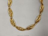 gros plan d'un bracelet en or sur une surface blanche