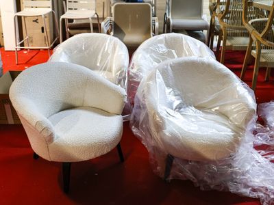 two chairs that are wrapped in plastic on the floor