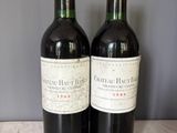 deux bouteilles de vin posées sur une table l'une à côté de l'autre