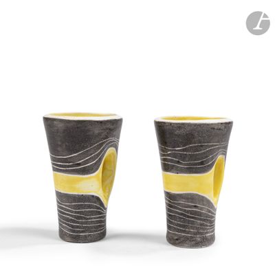 une paire de vases jaunes et noirs posés sur une surface blanche