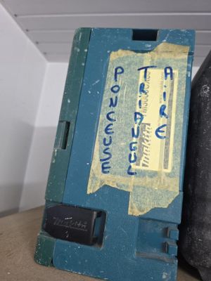 a blue box with a label on it sitting next to a black bag