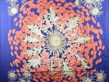 an orange and blue quilt with a circular design on it