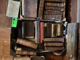 many old books on a shelf in the corner of a room