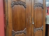 une grande armoire en bois dans une pièce où se trouve un miroir
