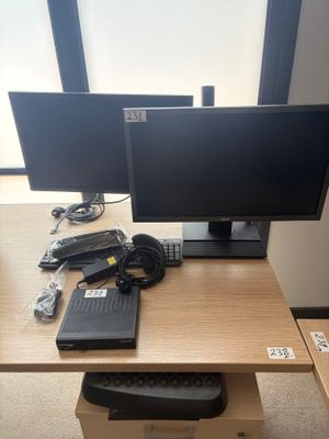a desk with two monitors and a keyboard on it