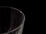 a glass with a liquid inside of it on a table