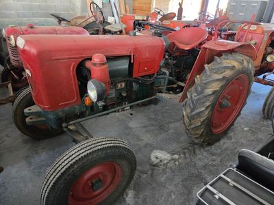 a red tractor that is parked in a garage