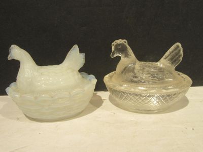 deux poulets en verre posés l'un à côté de l'autre sur une table
