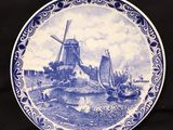 une assiette bleue et blanche avec un moulin à vent en arrière-plan