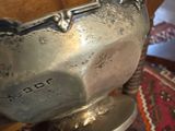 a silver bowl sitting on top of a wooden table