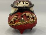 a small red vase with a gold dragon on it