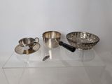a glass shelf with a bowl, cup, saucer, and spoon on it