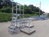a metal platform with a ladder on it in the middle of a parking lot