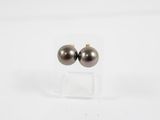 paire de boucles d'oreilles à clous en perles noires, présentées sur un support en acrylique transparent