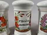 three ceramic jars with floral designs on them sitting on a table