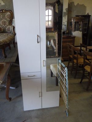 a tall white cabinet in the middle of a room