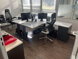 une photo d'un bureau avec un bureau et des écrans d'ordinateur